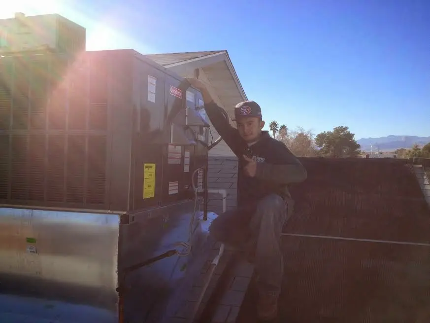 HVAC technician performing Heat Pump Repair on a rooftop unit in Oklahoma City